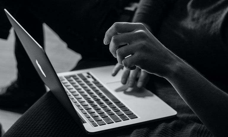 black and white image of person on laptop