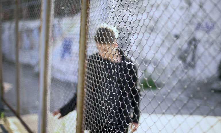 teenager behind a wire fence.jpg