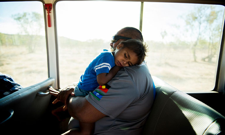 Indigenous man and child on a bus.