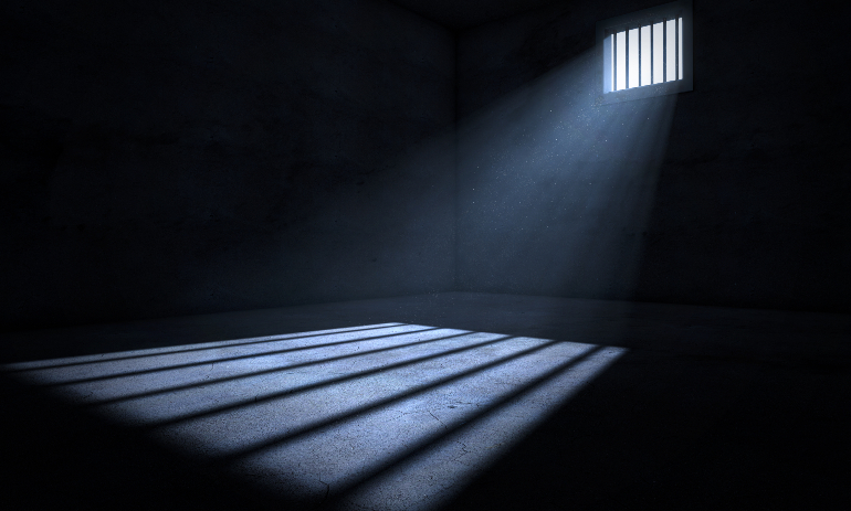 Empty prison cell with light shining through