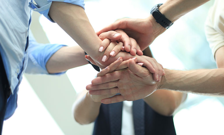 group of people with hands together in the middle
