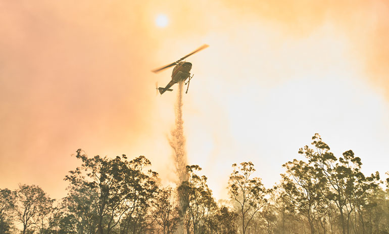 helicopter dropping water on a fire