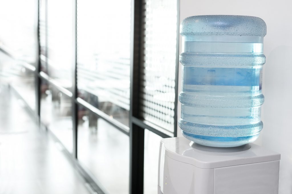 blue water gallon on electric water cooler in office area