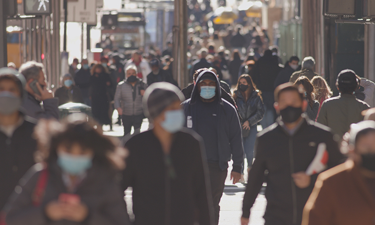 A busy street with people wearing facemasks.