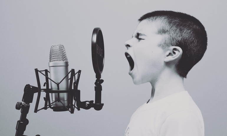 young boy shouting into a microphone