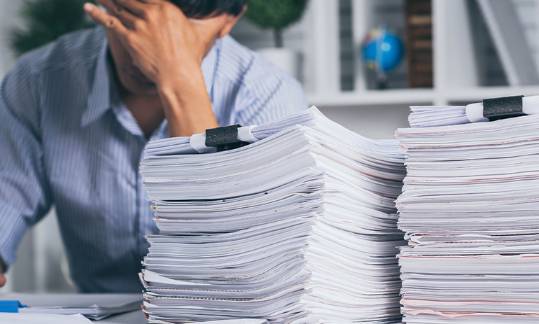 person surrounded by paperwork