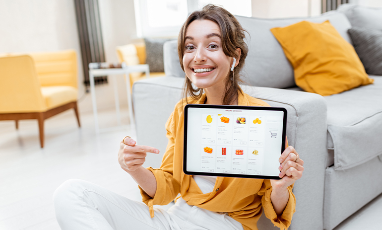 smiling girl pointing at website on her tablet