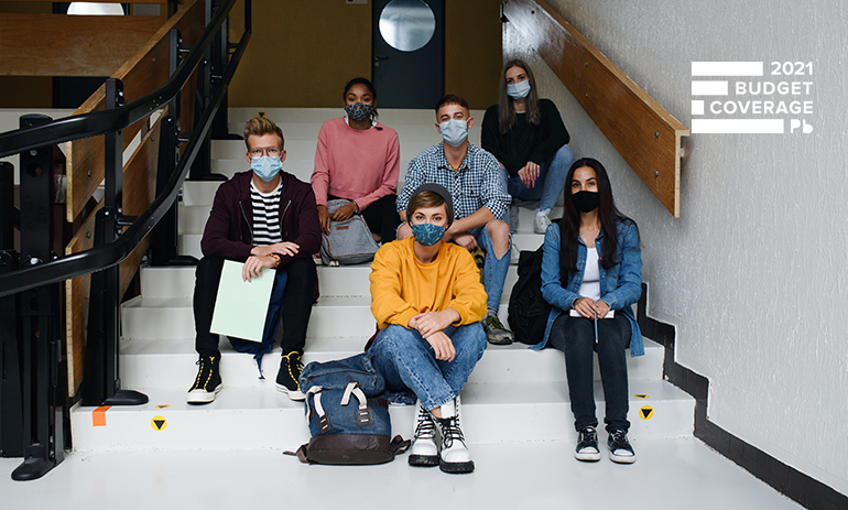 group of young people wearing face masks sitting on stairs.