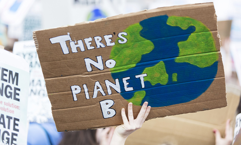 someone holds a handmade sign reading there is no planet b