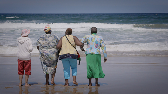 Rosemary with three other ladies standing in a line at the beach