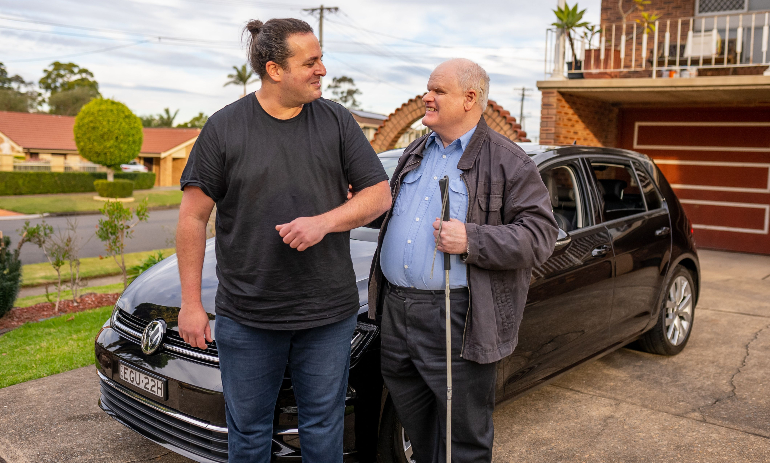 Person with disability with white cane and uber driver