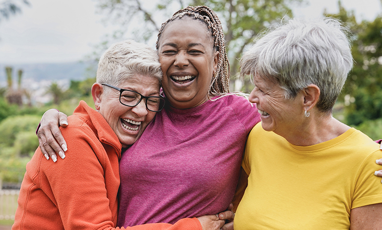 three diverse women laughing