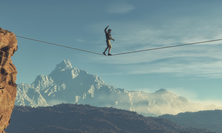 person on a tightrope in the mountains
