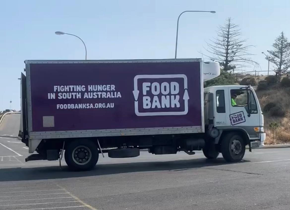 A large purple truck with food bank written on its side