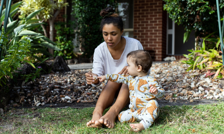 Woman sitting with a child on grass
