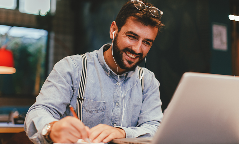 smiling man looking at his laptop