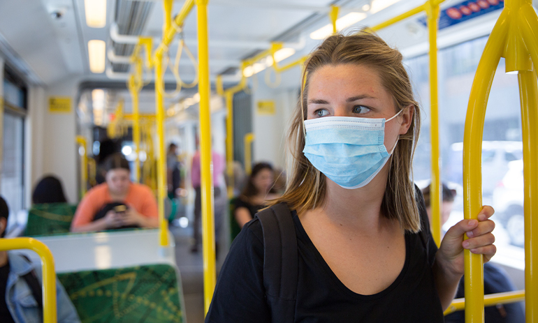 young woman wearing a face mask riding a Melbourne tram
