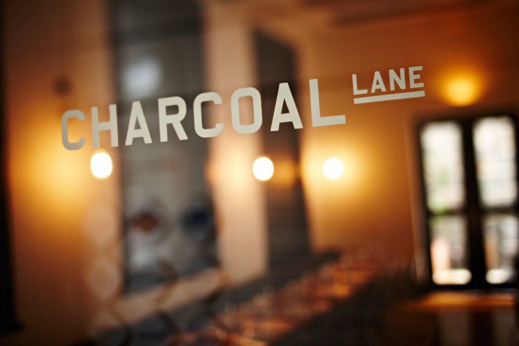 Charcoal Lane is etched into a glass door