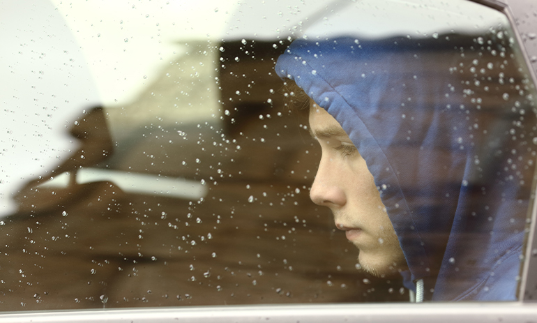 sad teenager looking out of a car window