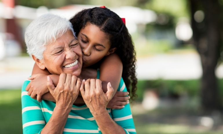 Older woman being hugged by young girl