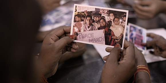 Geeta holding a photo of her at a peace march