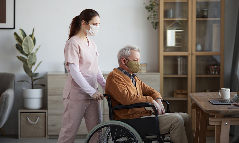 female disability support worker pushing a man in a wheelchair