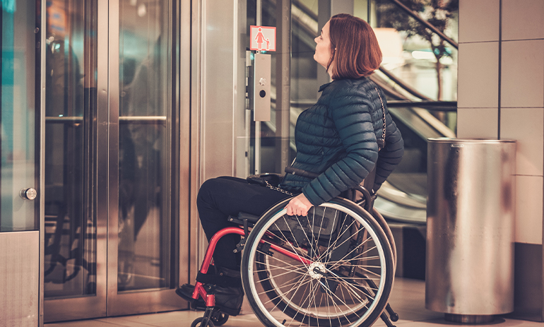 woman in wheelchair waiting for elevator