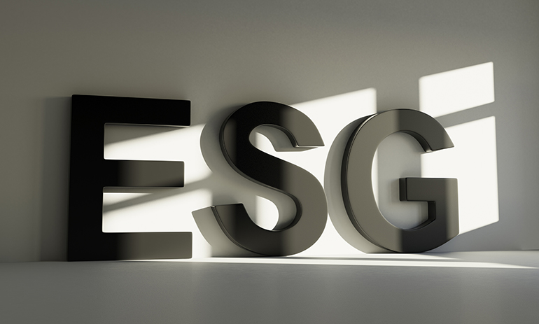 Letters ESG against grey background with reflection from the sun