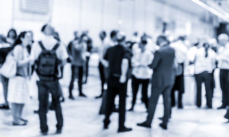 blurry black and white image of a group of people networking