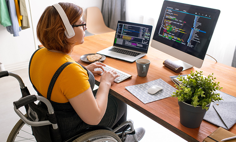 woman in wheelchair sitting at desk