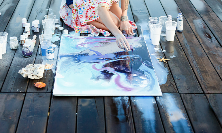 Someone painting outside on a deck