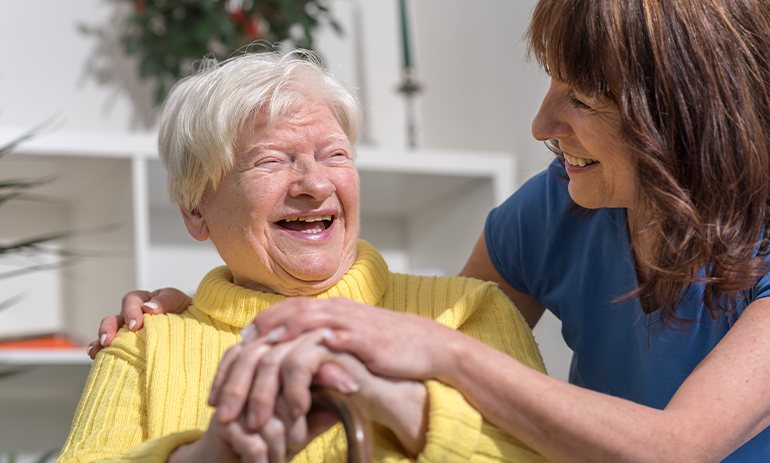 older woman laughing with a carer