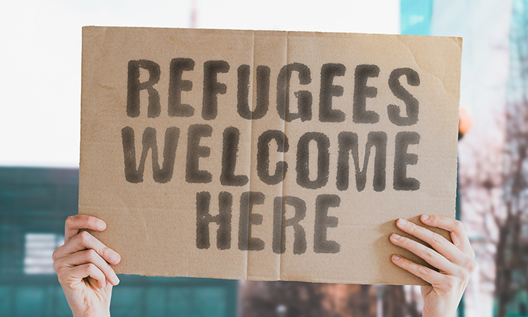 Person holding refugee sign