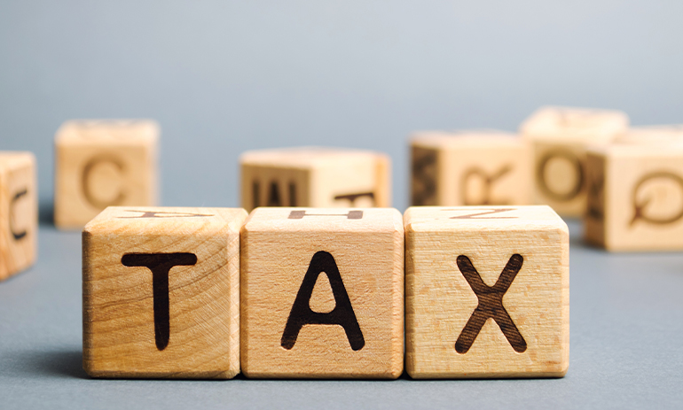 wooden blocks spell out the word tax