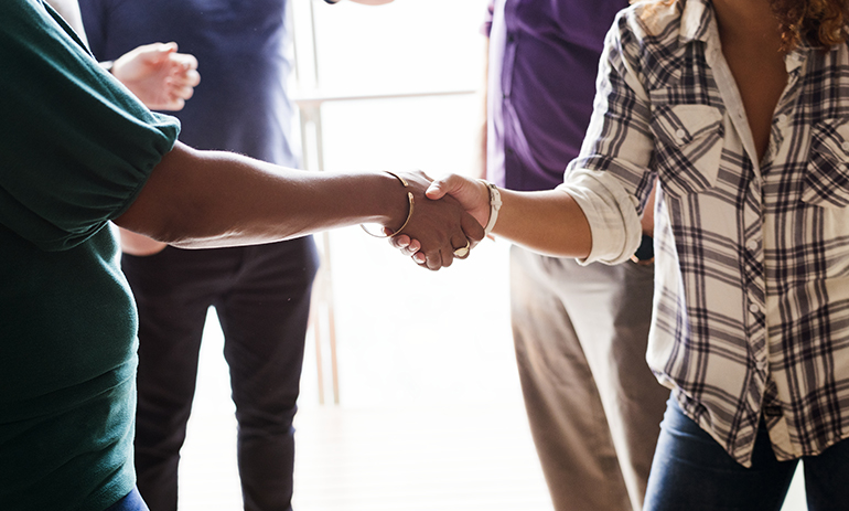 A close up of 2 people shaking hands