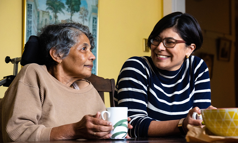 woman with her mother sitting side by side at a table.