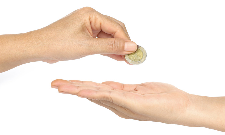 A hand places a coin in an outstretched hand