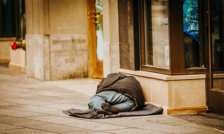 A person sleeping rough on a city street.