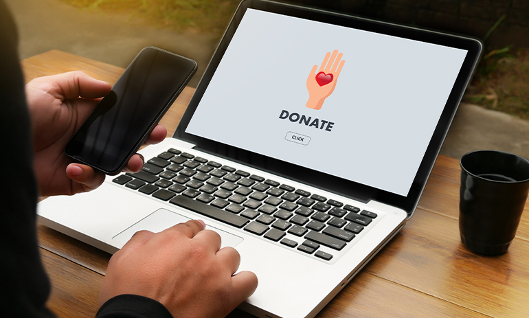 person looking at donate button on a website on a laptop