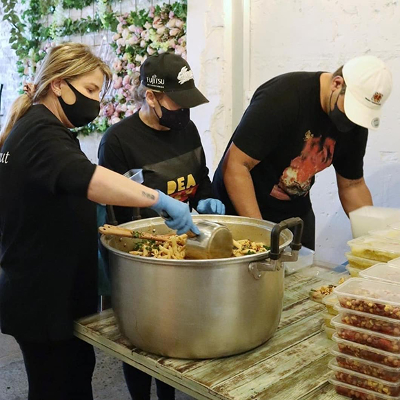 volunteers serving food from large pot