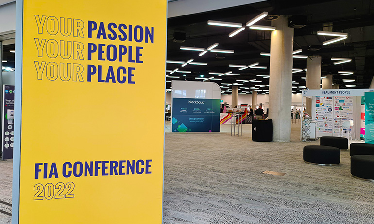 An image of the entry to the FIA Conference, with a yellow board that says Your Passion, Your People, Your Place FIA Conference 2022