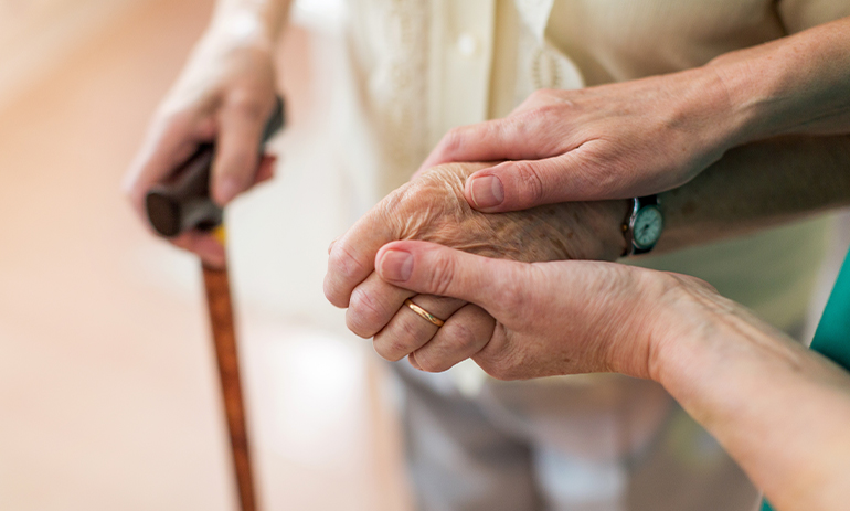close up someone holding the hand of an elderly woman