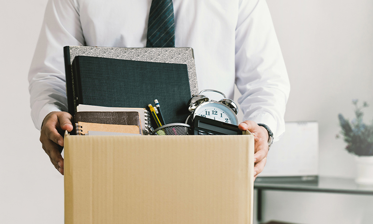 man leaving office with cardboard box of his things