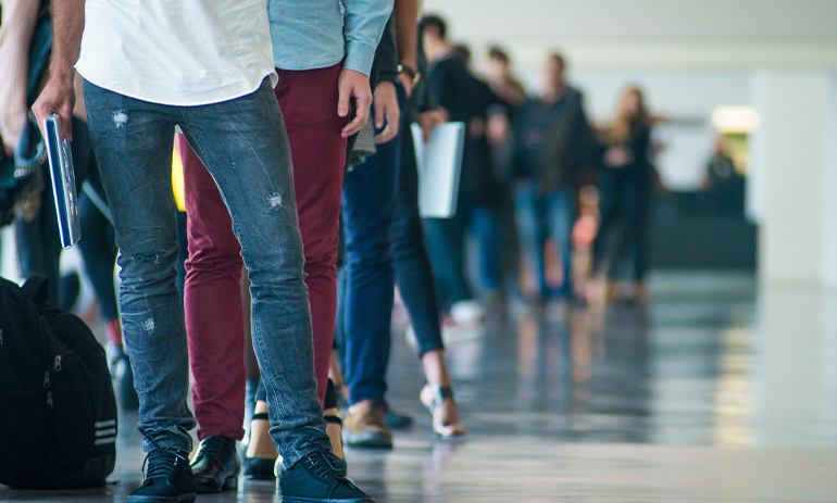 close up of people standing in a line waiting