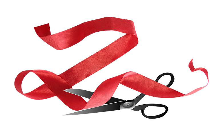A red tape being cut by a pair of scissors