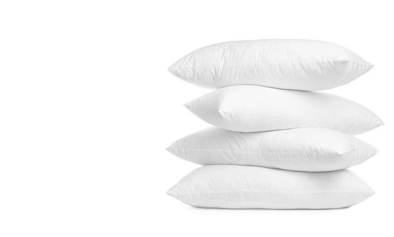 four white pillow stacked on top of each other