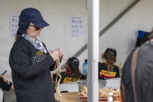 A person attends a cultural workshop and appears to be weaving.