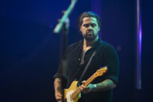 Dan Sultan, an Aboriginal man, plays the guitar on stage.