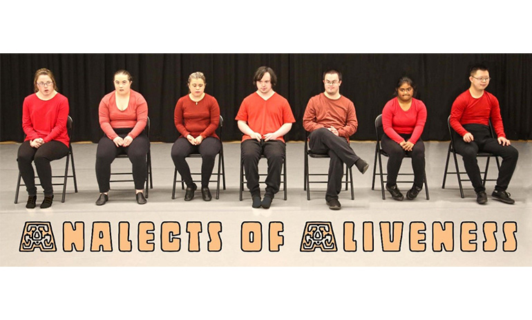 Seven people with Down syndrome sit in chairs on a stage, wearing red tops and black pants. The performance name, Analects of Aliveness, is written on the bottom of the picture.