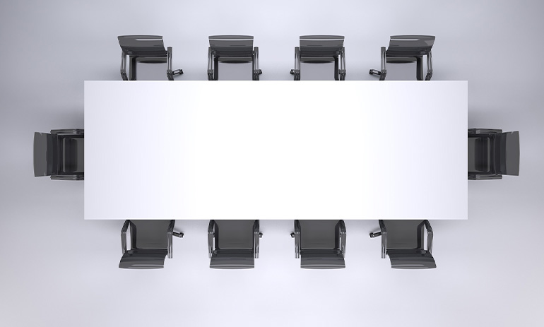 We're looking down at a boardroom table, with ten black chairs around a white rectangular table.